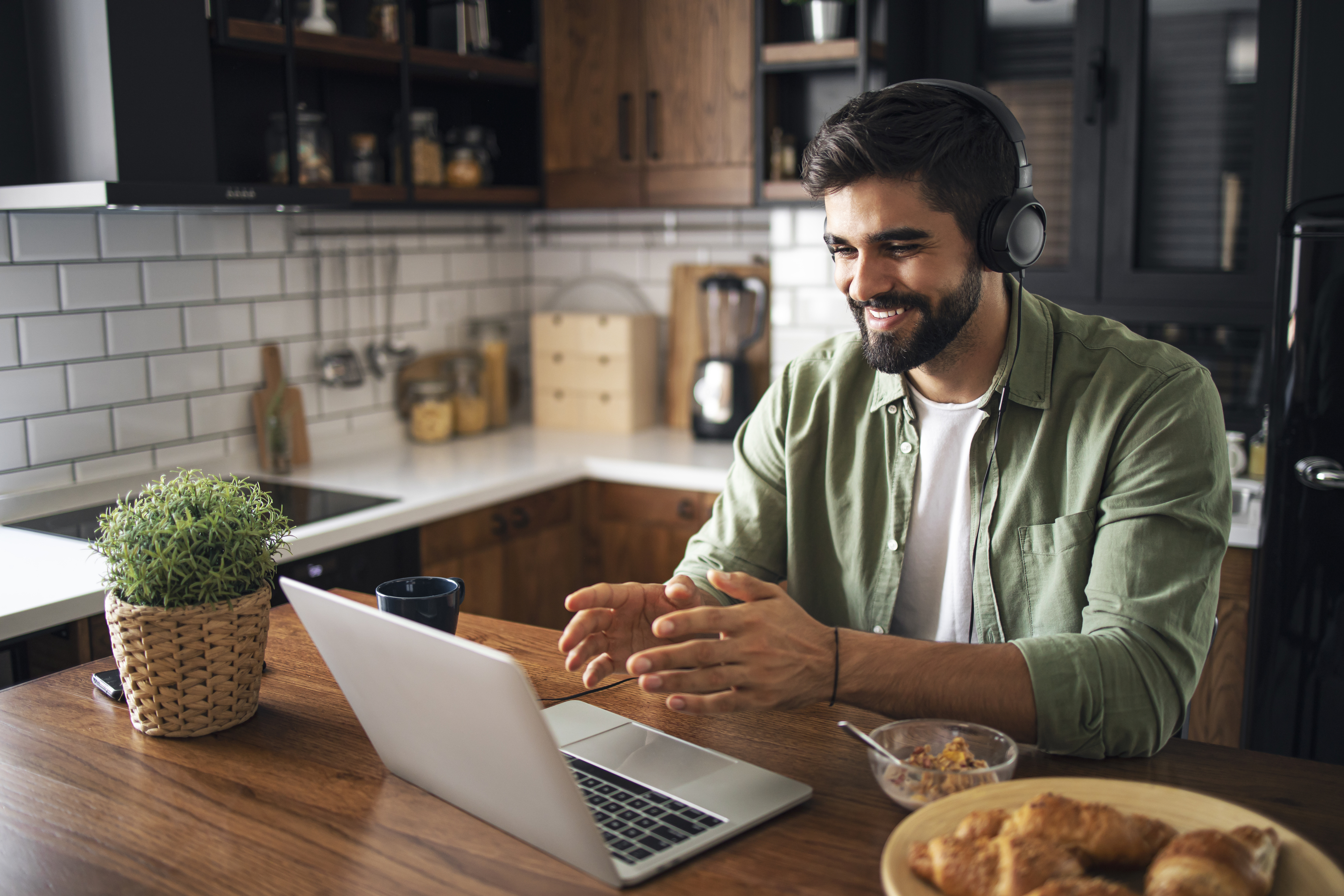 Person smiling at laptop in kitchen