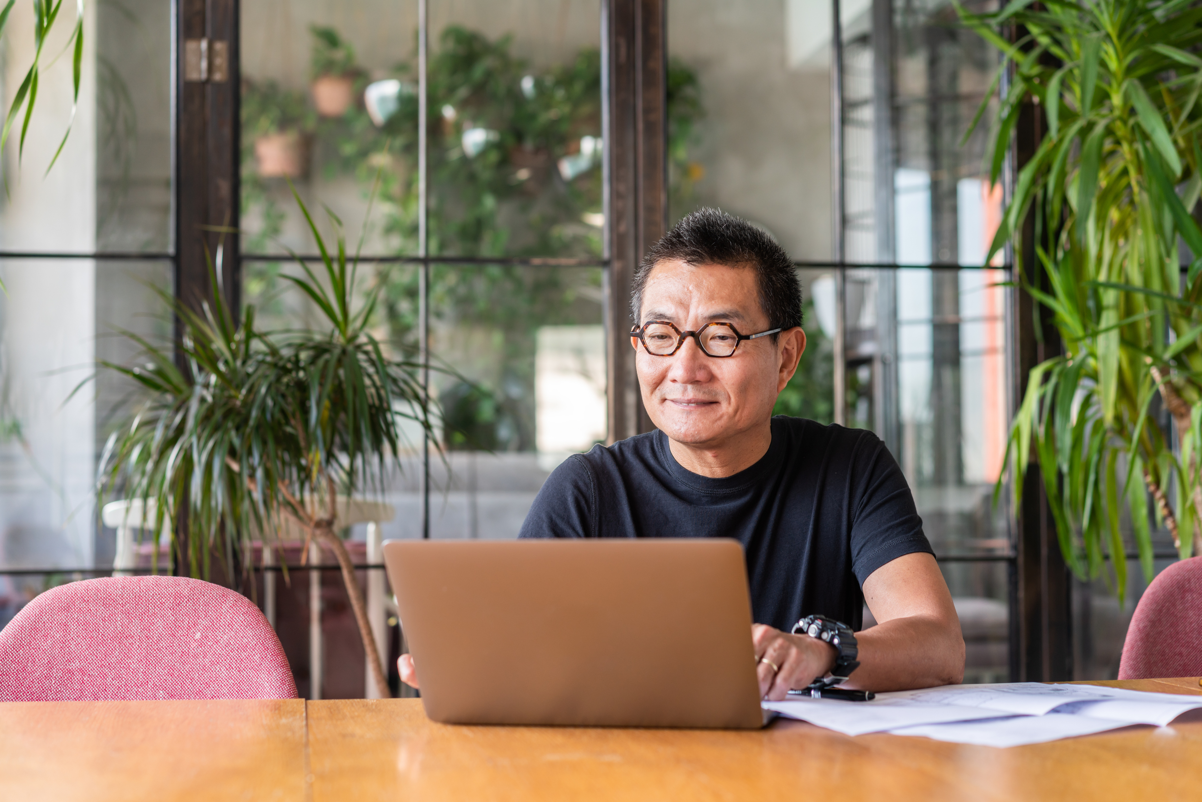 Person smiling at laptop in conference room